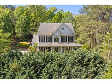 Charming two-story home with a welcoming front porch surrounded by lush greenery at 550 Vinings Springs Se Dr, Smyrna, GA 30126