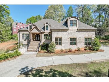 Beautiful brick home with arched windows, professionally landscaped yard, and inviting entrance at 6050 Eagle Close Ln, Sugar Hill, GA 30518