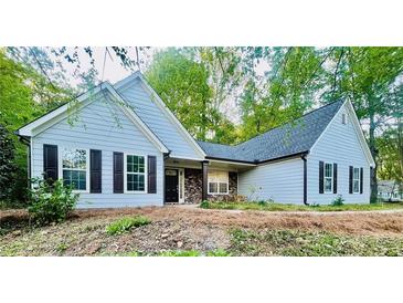 Charming single-story home with light-blue siding, black shutters, and a welcoming entrance with stone accents at 7675 Lanier View Rdg, Cumming, GA 30041