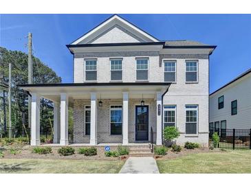 Charming two-story home featuring a welcoming front porch with elegant columns and a well-manicured lawn at 3003 Evanshire Ave, Duluth, GA 30096