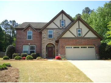 Charming two-story brick home with stone accents, a two-car garage, and a well-manicured front lawn at 3215 Trowbridge Dr, Cumming, GA 30040