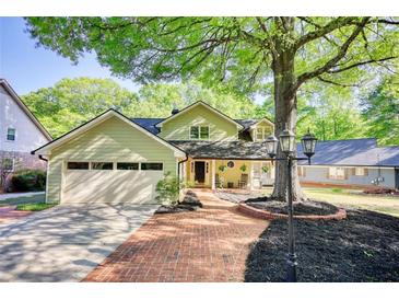 Charming home featuring a brick walkway, mature trees, a front porch with seating, and an attached garage at 4157 Town Branch Ct Sw, Covington, GA 30014