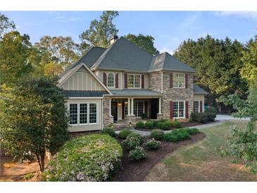 Charming stone facade home with lush landscaping, dormer windows, and inviting front porch at 519 River Estates Pkwy, Canton, GA 30115