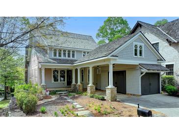Charming home featuring stone accents, a covered front porch, and an attached two-car garage at 7160 Round Rd, Cumming, GA 30040