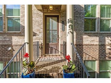 Charming brick home featuring a welcoming front porch with columns, potted plants, and a stately front door at 1200 Virginia Ct # 101, Atlanta, GA 30306