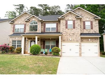 Charming two-story brick home with a well-manicured lawn and attached two-car garage at 3830 Kittery Pt, Snellville, GA 30039