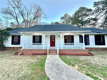 Charming single-story home with a welcoming front porch, red door, and well-maintained lawn at 134 Carrollwood Dr, Fayetteville, GA 30215
