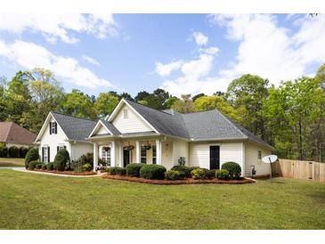 Charming one story home with manicured lawn and inviting front porch, surrounded by lush greenery at 794 Lucas Dr, Hampton, GA 30228