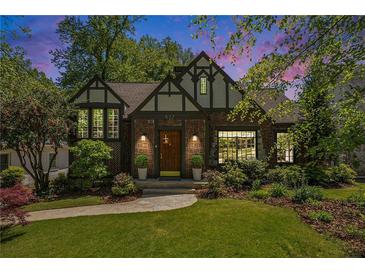 Charming Tudor-style home with a well-manicured lawn, beautiful landscaping, and classic architectural details at 937 E Rock Springs Ne Rd, Atlanta, GA 30306