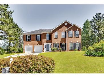 Charming two-story brick home with a well-manicured lawn and a two-car garage at 3710 Burling Rdg, Lithonia, GA 30038