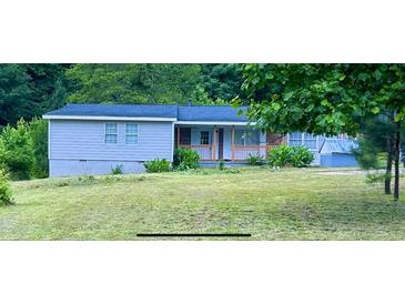 Charming single-story home with a covered front porch, nestled amongst lush greenery at , Covington, GA 30014