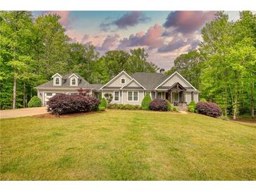 Well-maintained home with a gray exterior, lush greenery, and a serene, tree-lined backdrop at 1080 Gaithers Rd, Mansfield, GA 30055