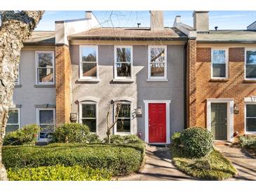 Charming townhome with a stucco facade, red front door, and manicured landscaping at 3476 Silver Maple Dr, Duluth, GA 30096
