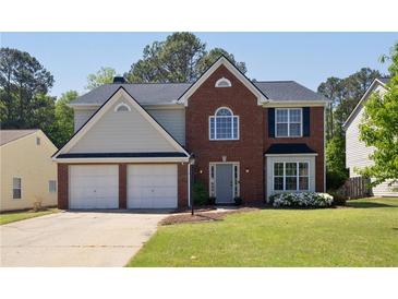 Charming two-story home with brick facade, attached two car garage and well-manicured lawn at 1553 Pinebreeze Dr, Marietta, GA 30062