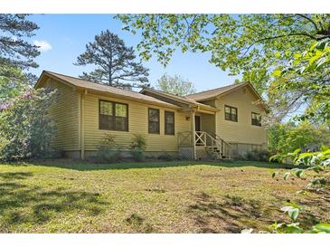 Charming home featuring a well-maintained lawn, inviting entrance, and classic architectural details under a clear blue sky at 2062 Skyhawk Ln, Acworth, GA 30102