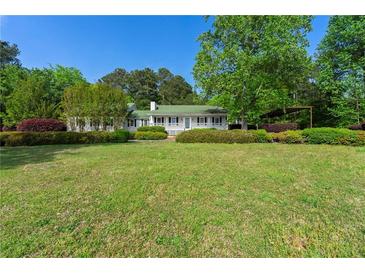 Charming single-story home with a lush front lawn and manicured landscaping creating a welcoming curb appeal at 1170 Moseley Rd, Stockbridge, GA 30281