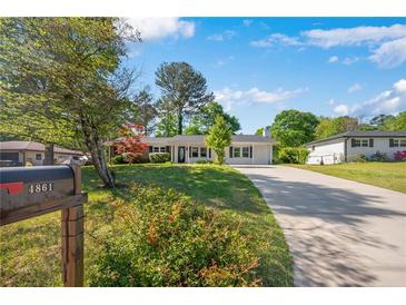 Charming single-story home with a well-manicured lawn, mature trees, and a long driveway leading to the garage at 4861 Alcan Rd, Powder Springs, GA 30127