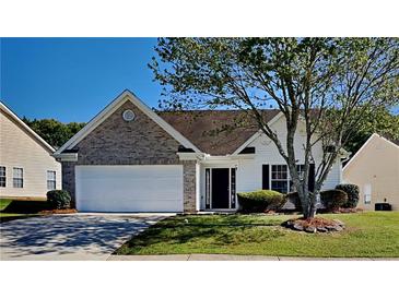 Charming single-story home featuring a brick facade, manicured lawn, and attached two-car garage at 145 Charleston Pl, Covington, GA 30016
