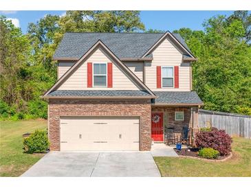 Charming two-story home with a stone accent garage, red shutters, and a landscaped front yard at 100 Cottage Nw Walk, Cartersville, GA 30121