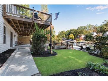 Lush backyard with a wooden deck, patio, and lake access, perfect for outdoor entertaining at 10005 Lakeview Pkwy, Villa Rica, GA 30180