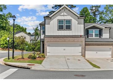 Charming townhome with a two-car garage, brick accents, and well-maintained landscaping at 1385 Vayda Ct, Marietta, GA 30066