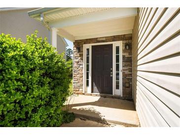 Inviting front entry featuring a stone facade, covered porch, and a dark-stained front door at 11151 Aliyah Dr, Hampton, GA 30228