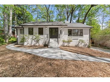Charming brick home featuring a landscaped front yard, updated windows and inviting entryway steps at 3915 Ivy Ne Rd, Atlanta, GA 30342