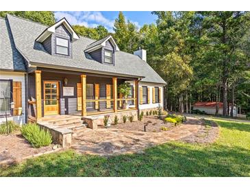 Charming home featuring a stone walkway leading to a covered front porch with wooden columns and shuttered windows at 4392 Lower Fayetteville Rd, Sharpsburg, GA 30277