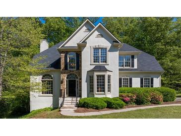 Charming stucco home featuring a well-manicured lawn, arched windows, and a stone accent entry at 1820 Lyon Sw Ave, Atlanta, GA 30331