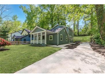 Charming home with a covered front porch, well-manicured lawn, and a long driveway at 214 Adeline Nw Ave, Atlanta, GA 30314