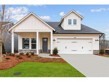 Charming home featuring white siding, stone accents, and a convenient two-car garage at 235 Strawberry Ln, Woodstock, GA 30189