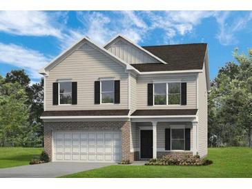 Charming two-story home featuring vinyl siding, a brick foundation, and an attached two-car garage at 26 Kensington St, Kingston, GA 30145