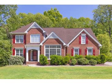 Charming two-story brick home featuring red shutters and well-manicured front lawn at 2945 Barimore Pl, Dacula, GA 30019