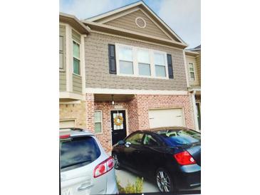 Charming townhome featuring a brick facade, neutral siding, and a welcoming front door with a decorative wreath at 3203 Cyrus Point Nw Ln, Kennesaw, GA 30152