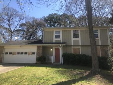 Two story house with a stone facade, lawn, and a two car garage at 432 Rock Meadow Dr, Stone Mountain, GA 30088
