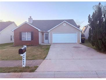 Charming single-story home featuring a brick facade, attached garage, and well-maintained front lawn at 11447 Vinea Ln, Hampton, GA 30228