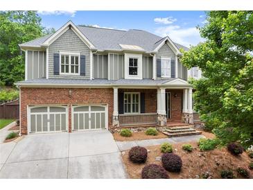 Beautiful two-story home with a brick and gray facade, two-car garage, and a welcoming front porch at 1286 Whisper Cove Dr, Buford, GA 30518