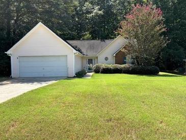 Charming single story home featuring an attached two car garage and well maintained lawn at 159 Parkside Dr, Stockbridge, GA 30281