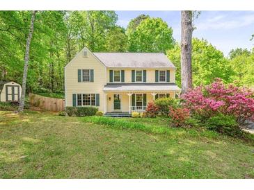 Charming two-story home with green shutters, landscaping, and mature trees at 3627 Pebble Hill Ne Dr, Marietta, GA 30062