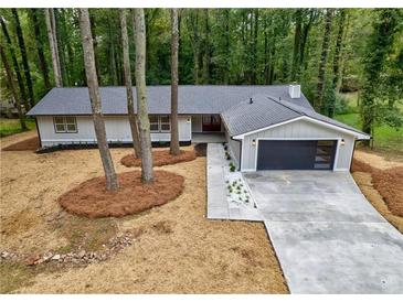 Charming home with new driveway, attached garage, trees in the yard, and beautiful forest view at 1329 Hidden Hills Pkwy, Stone Mountain, GA 30088