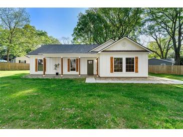 Charming one-story home with white siding, wood accents, a well-manicured lawn and a welcoming front entrance at 1921 Hazelwood Se Dr, Marietta, GA 30067