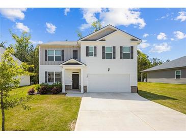 Charming two-story home featuring a manicured lawn, two-car garage, and neutral color palette at 1196 Erica Se Way, Atlanta, GA 30354