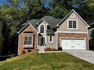 Charming two-story home features stone accents, a two-car garage, and a well-maintained lawn at 3045 Wyntree Dr, Peachtree Corners, GA 30071