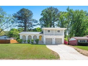 Charming two-story home featuring a beautiful brick facade, arched porch, second story balcony and well-maintained lawn at 4269 Indian Forest Trl, Stone Mountain, GA 30083