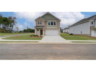 Charming two-story home with brick facade, a well-manicured lawn, and an attached two-car garage at 40 Begonia Ct, Covington, GA 30016