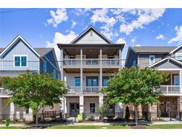Charming three-story townhome with double balconies and a fenced front yard at 1434 Fairmont Ave, Atlanta, GA 30318