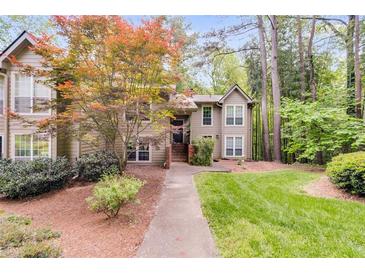 Inviting townhouse featuring manicured lawn, mature trees, and a classic exterior at 2901 Ne Lenox Rd # 305, Atlanta, GA 30324