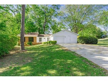 Charming home with a brick facade, white garage, and lush green lawn at 2254 Lisbon Ln, Jonesboro, GA 30236