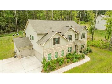 Charming two-story home featuring stone accents, a three-car garage and a beautifully landscaped front yard at 475 Mcdonough Rd, Fayetteville, GA 30214