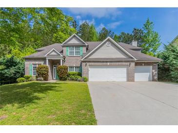 Charming two-story brick home with a well-manicured lawn, three-car garage, and tasteful landscaping at 6757 Delaware Bnd, Fairburn, GA 30213